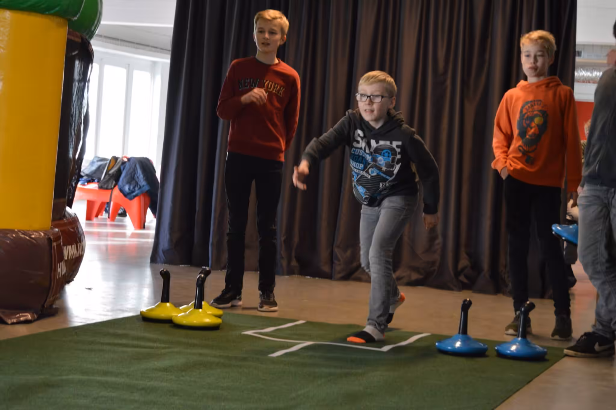 Kinderen spelen curling binnenshuis op kunstgras