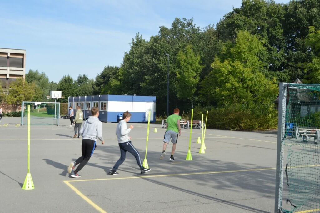 Jongens slalom rond stokken