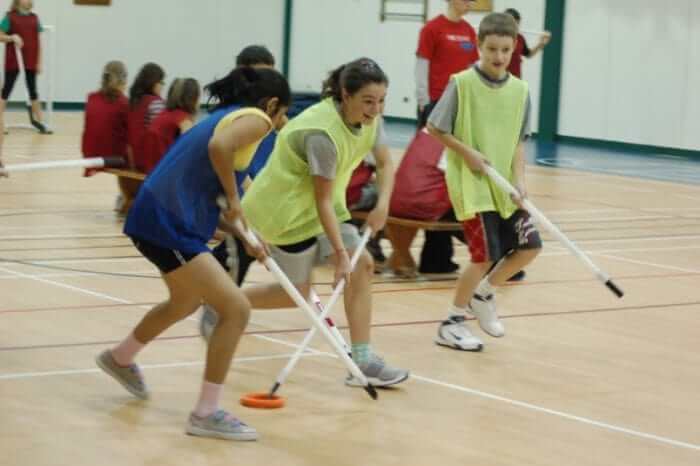 Meisje lacht geel flue hesje gym ringette