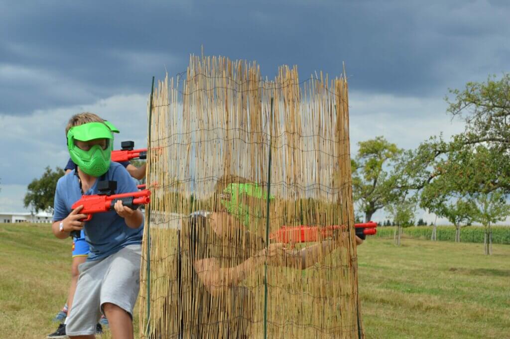 Paintball achter rieten obstakel met rode shotguns