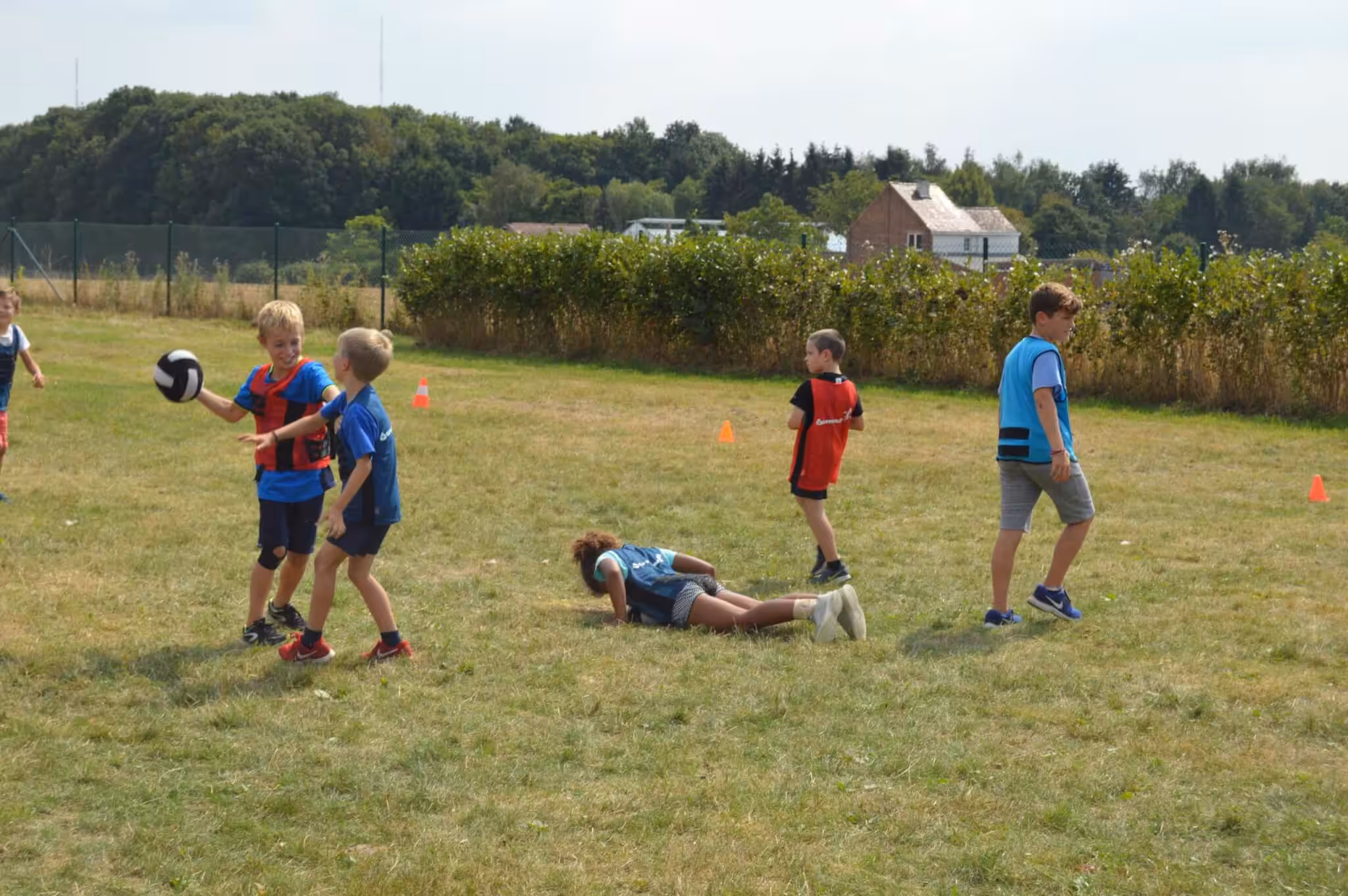 Kinderen spelen met een bal in het grasveld.
