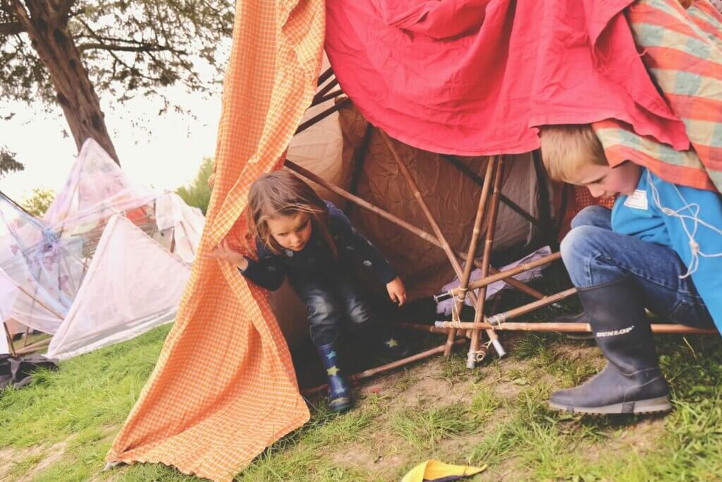 jongen en meisje komen uit rode tent