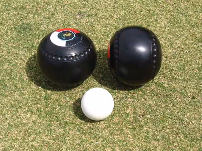 Bowlingsballen en kleine witte bal op grasveld
