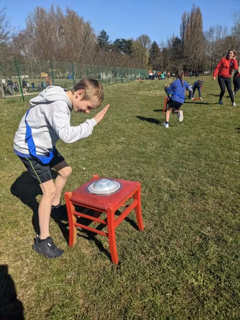 Kinderen spelen spelletjes op grasveld onder zon.