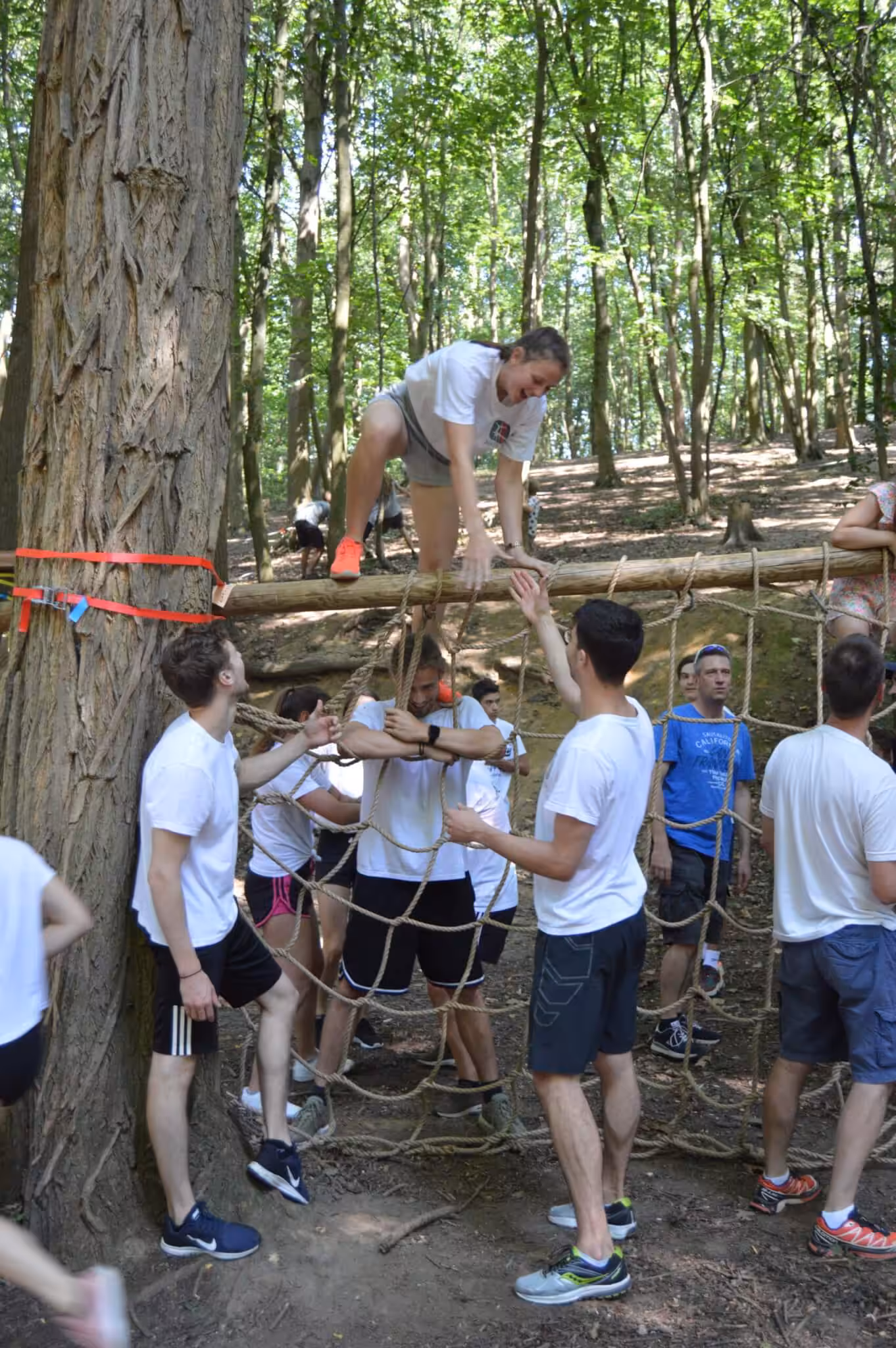Groep mensen doet outdoor teambuilding in het bos.