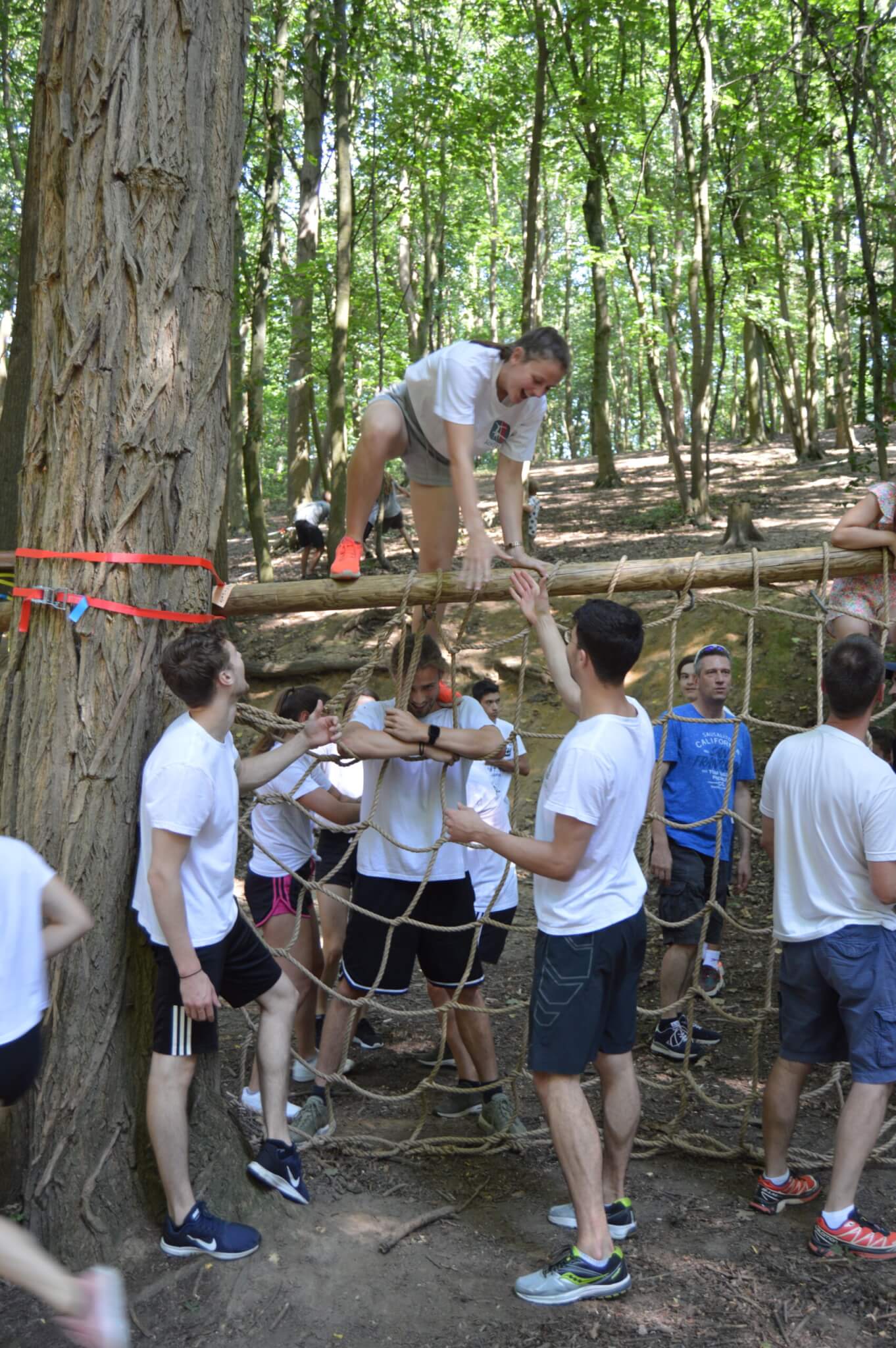 volwassenen klimmen over net in bos