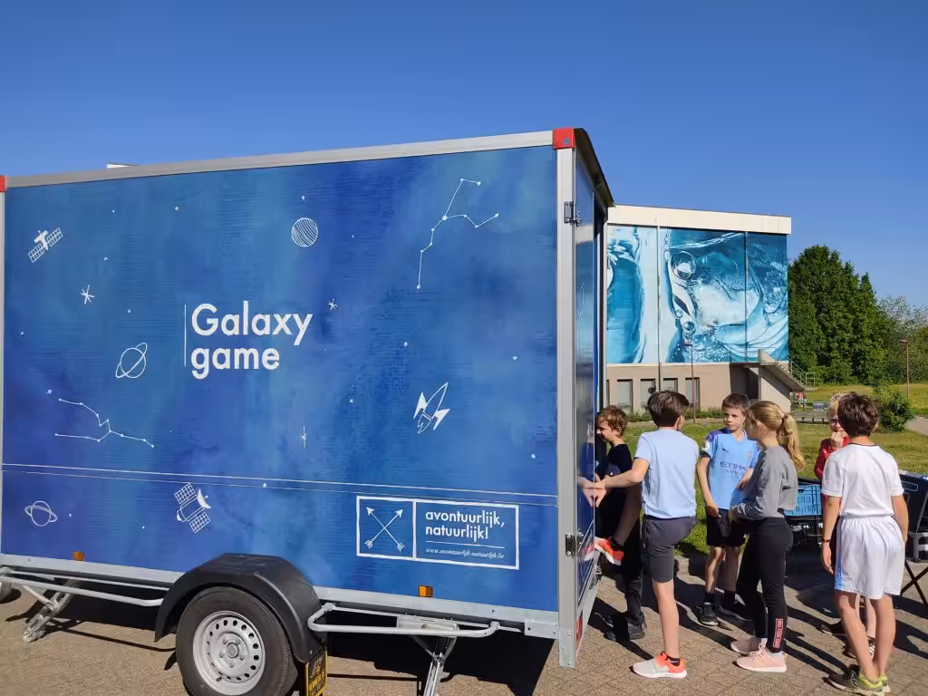 Kinderen spelen bij Galaxy Game vrachtwagen op zonnige dag.
