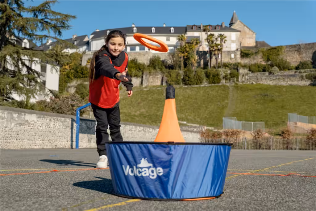 Meisje speelt frisbee in openlucht met hindernis.